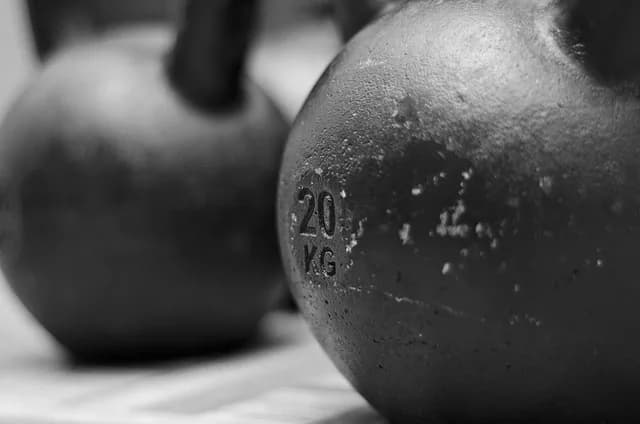 Heavy black kettlebells on a gym floor